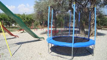 A playground with a trampoline, a slide, and various play structures.