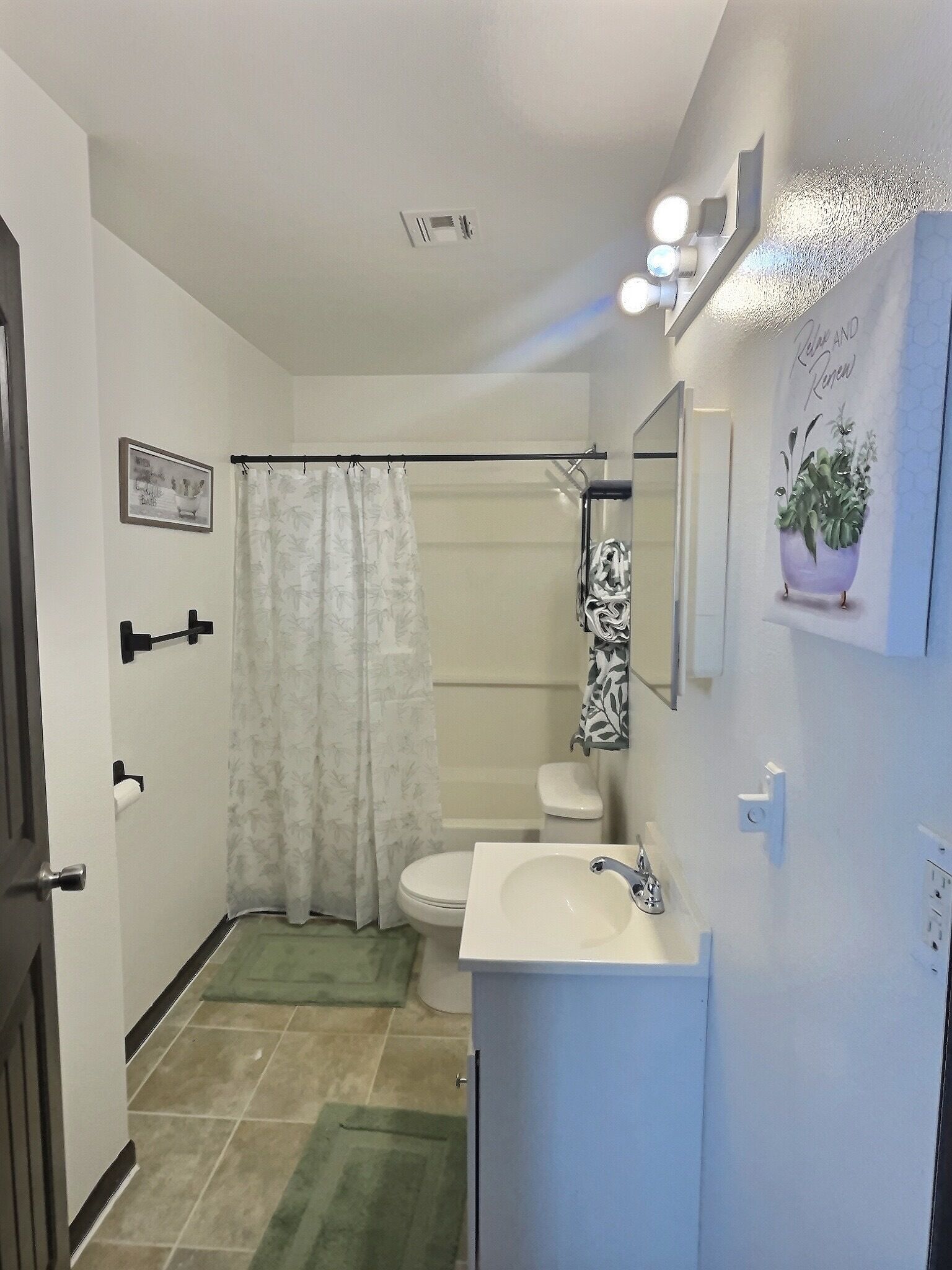 Baño con inodoro, lavamanos, ducha y toallero.