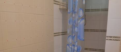 A bathroom with a shower, a sink, and a toilet.