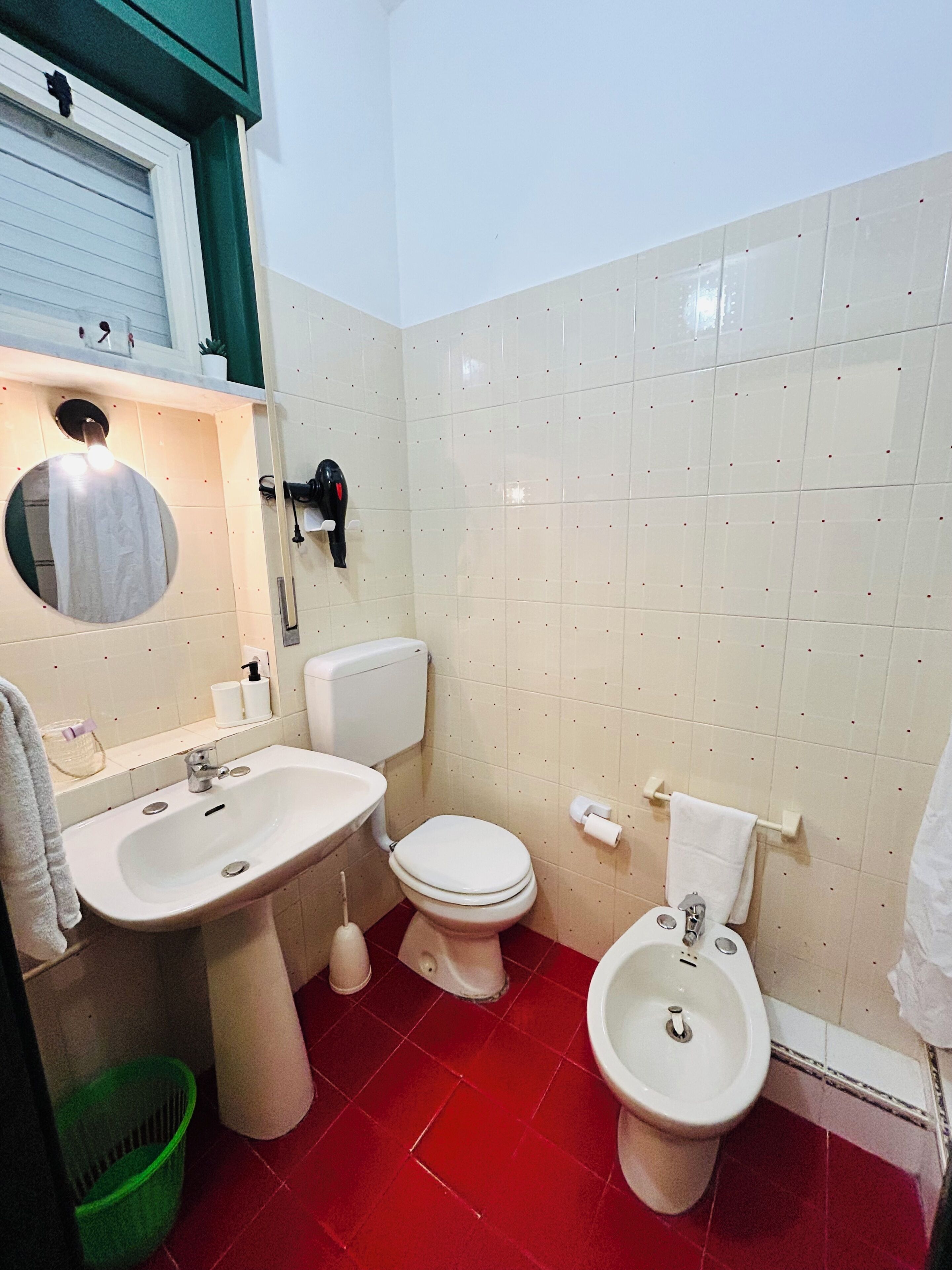 Un baño con lavabo, inodoro, bidé y espejo.