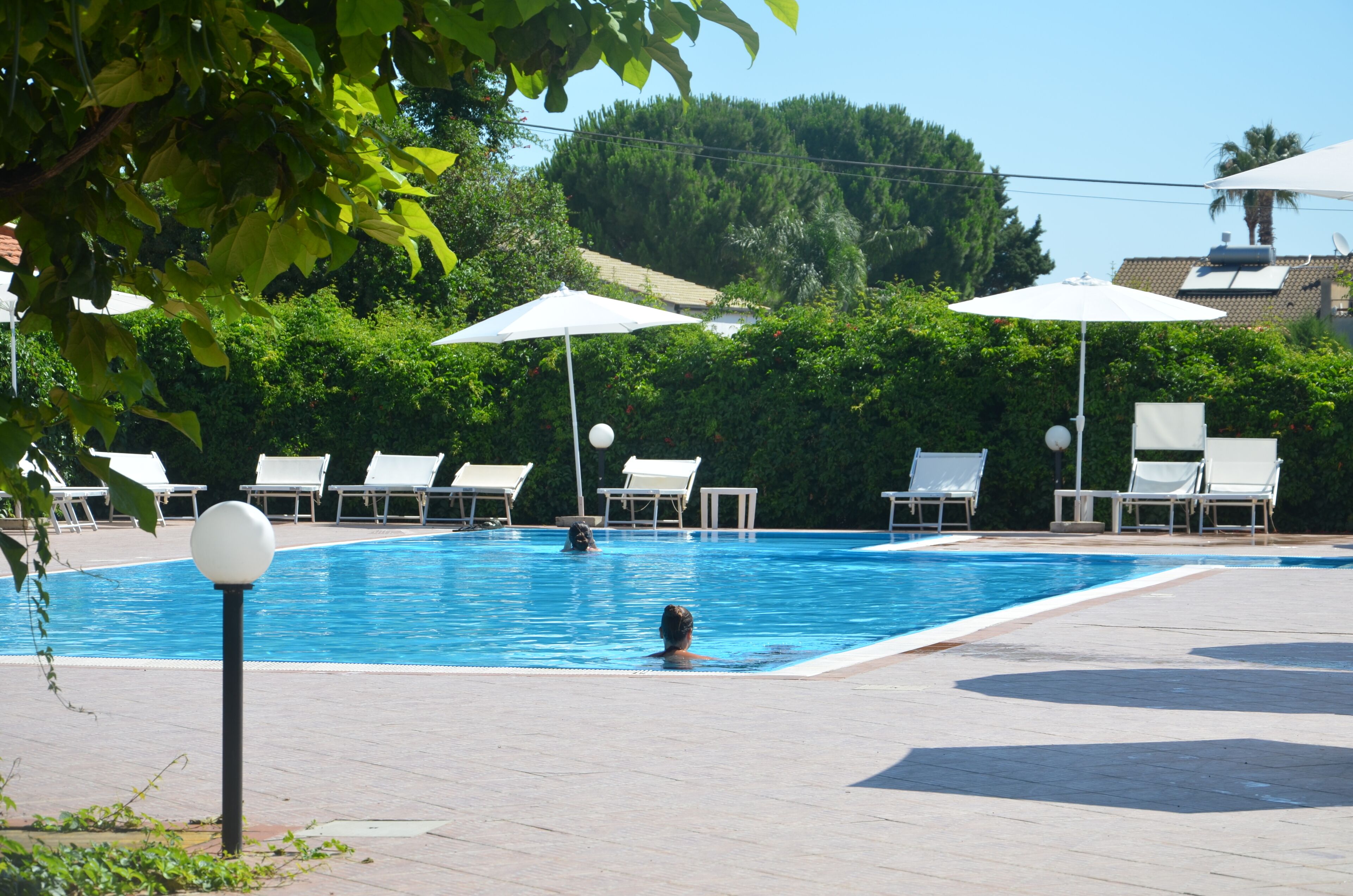Una piscina con sillas de descanso y sombrillas.