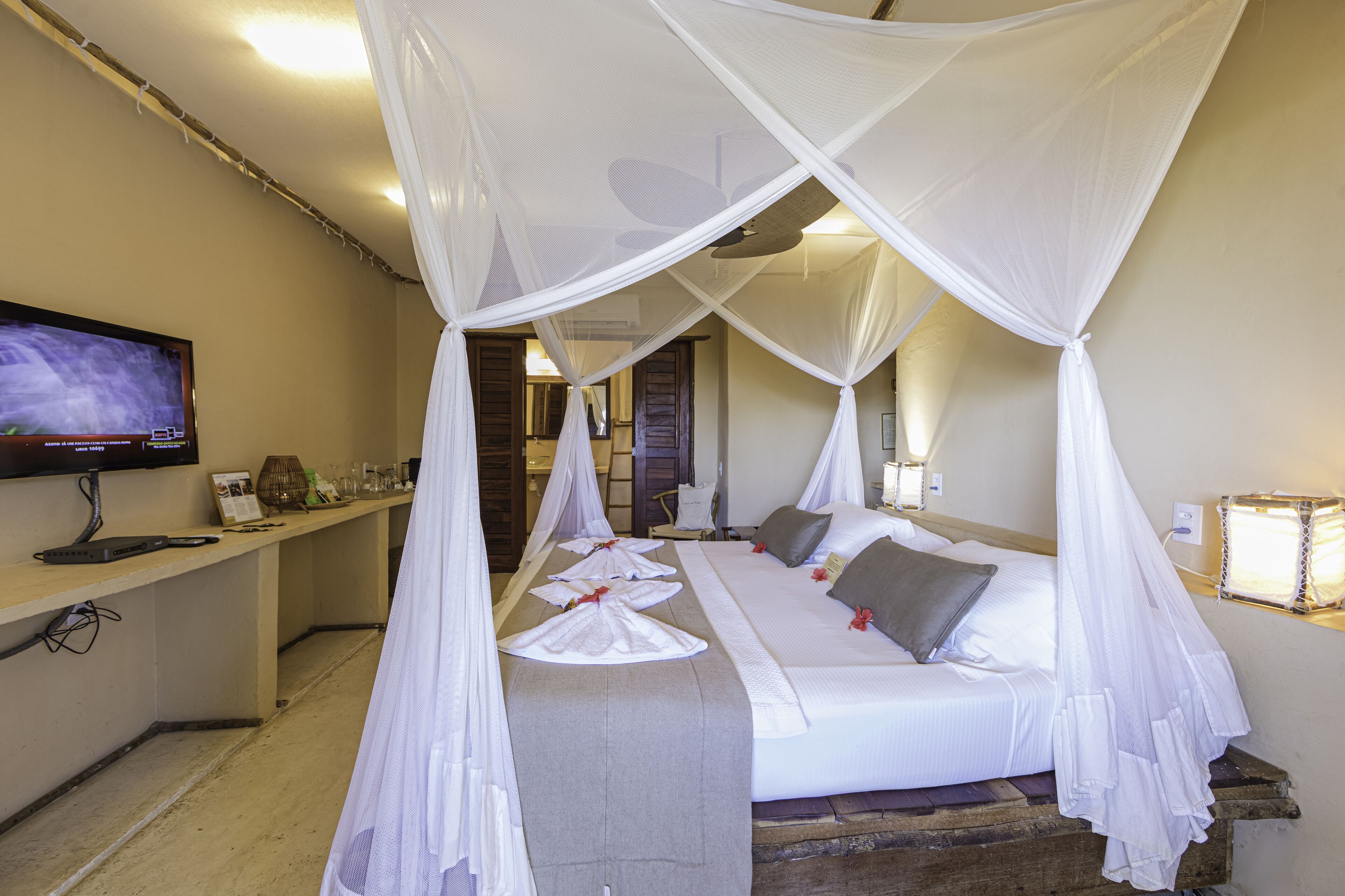 Una habitación de hotel con cama, televisión, escritorio y mesita de noche.