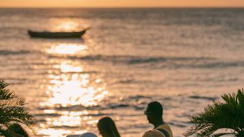 En la playa, arena blanca, sillas reclinables de playa, sombrillas