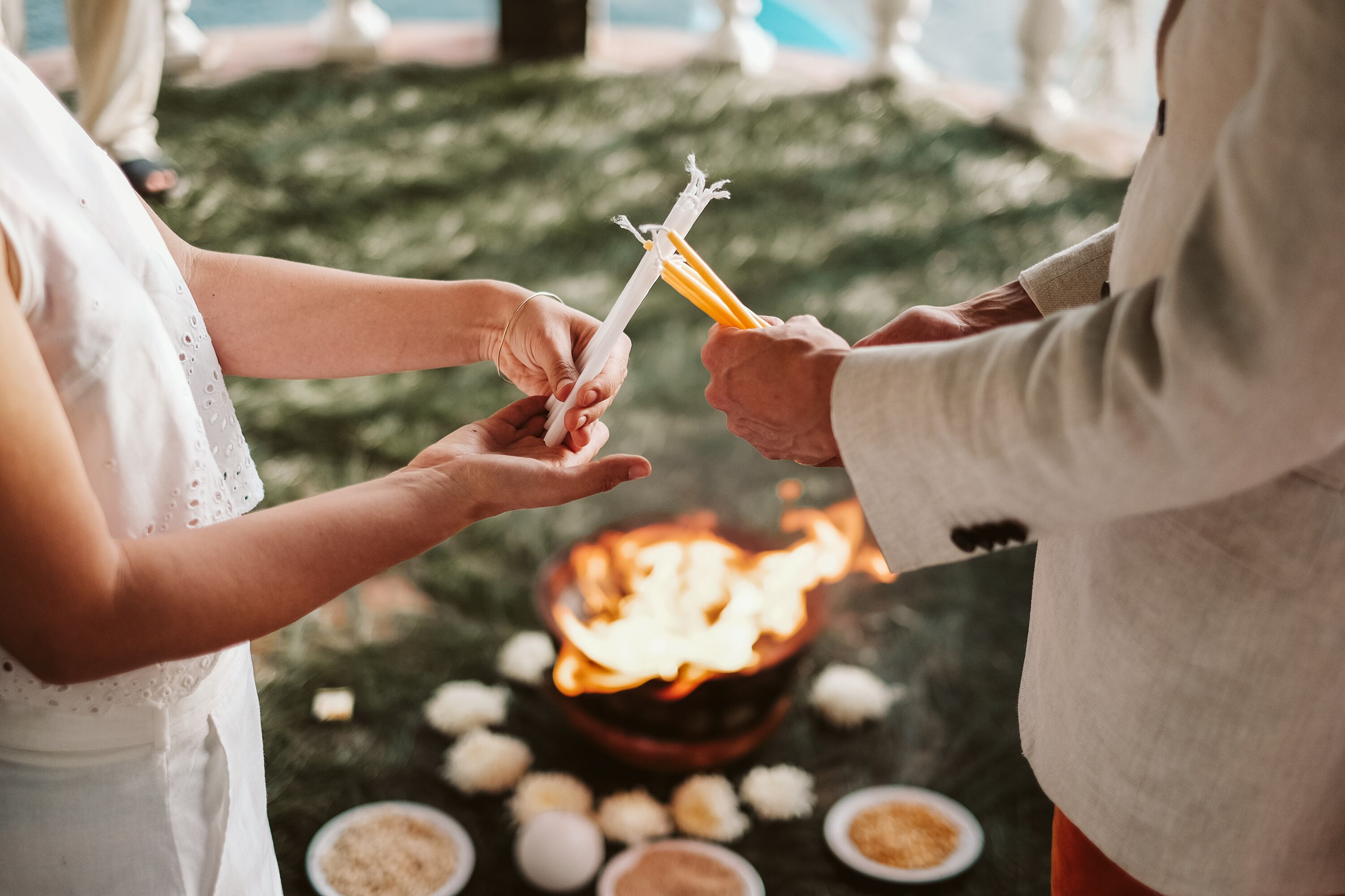 A ceremonial fire with guests holding white and yellow candles.