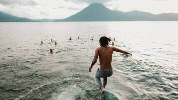A person walking on a body of water with mountains in the background.