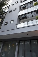 A modern building with multiple balconies, large windows, and a flat facade.