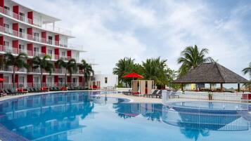 Una piscina al aire libre, camas de piscina gratis, sombrillas