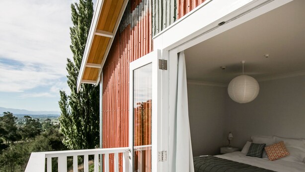 Un dormitorio con cama, mesita de noche y lámpara colgante.