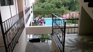 A staircase with a pool view, surrounded by greenery and a tiled floor. - Hotel Balcon Gueela (Santa María Huatulco)
