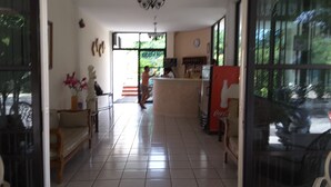 A spacious hallway with a tiled floor leading to a kitchen area with a refrigerator and a sink. - Hotel Balcon Gueela (Santa María Huatulco)