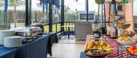 A buffet setup with various food items and a view of the outdoors.
