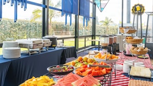 A buffet table with various food items and a view of the outdoors. - Pop Art Hotel Tocancipa y Centro de Convenciones (Tocancipá)