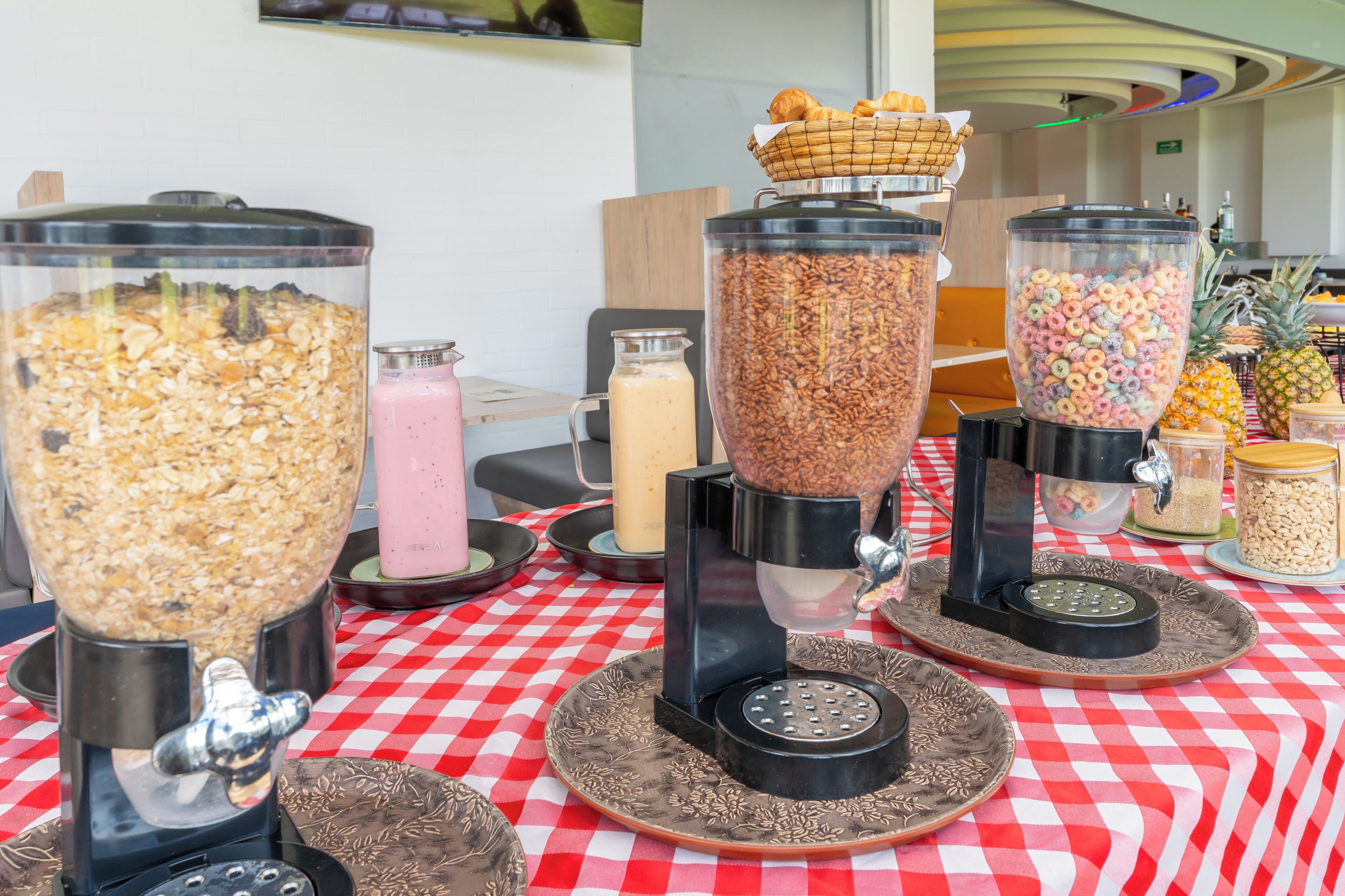 A buffet table with various food dispensers, including granola, cereal, and other breakfast items.
