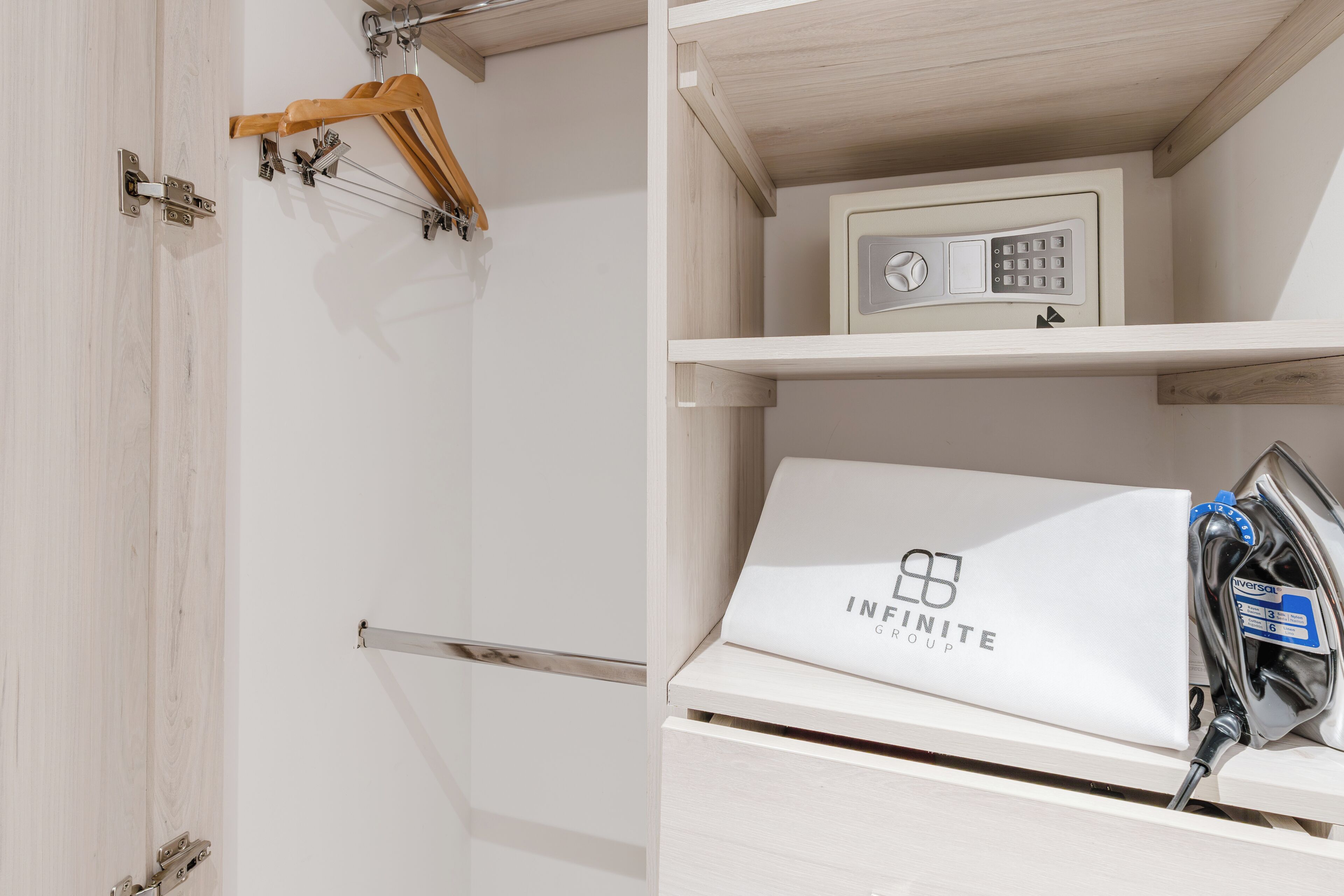 A wardrobe with a hanging rack and a drawer containing a white bag with 'INFINITE GROUP' text.
