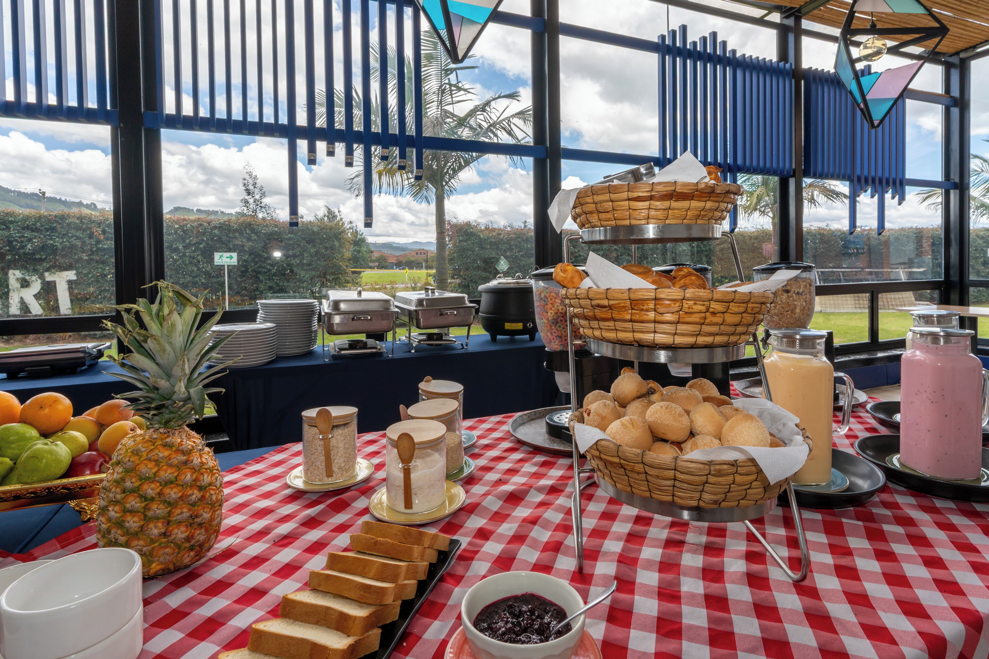 A buffet setup with various food items and condiments on a checkered tablecloth.