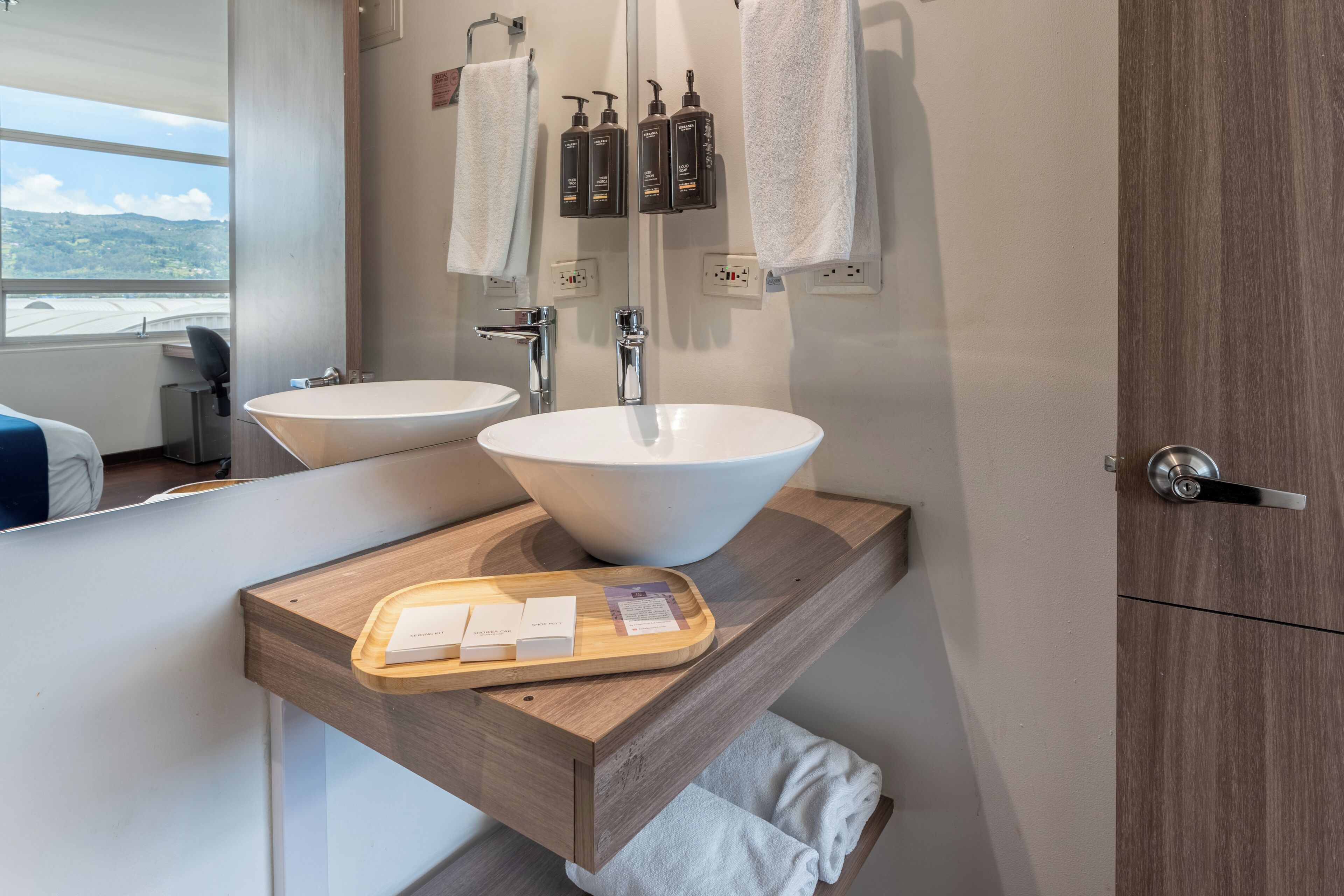 Une salle de bain moderne avec deux vasques, un grand miroir et un meuble-lavabo en bois.