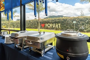 Un buffet composé de différents récipients contenant de la nourriture et d’une pancarte sur laquelle est écrit « POPART », accompagnée d’un symbole en forme de cœur.