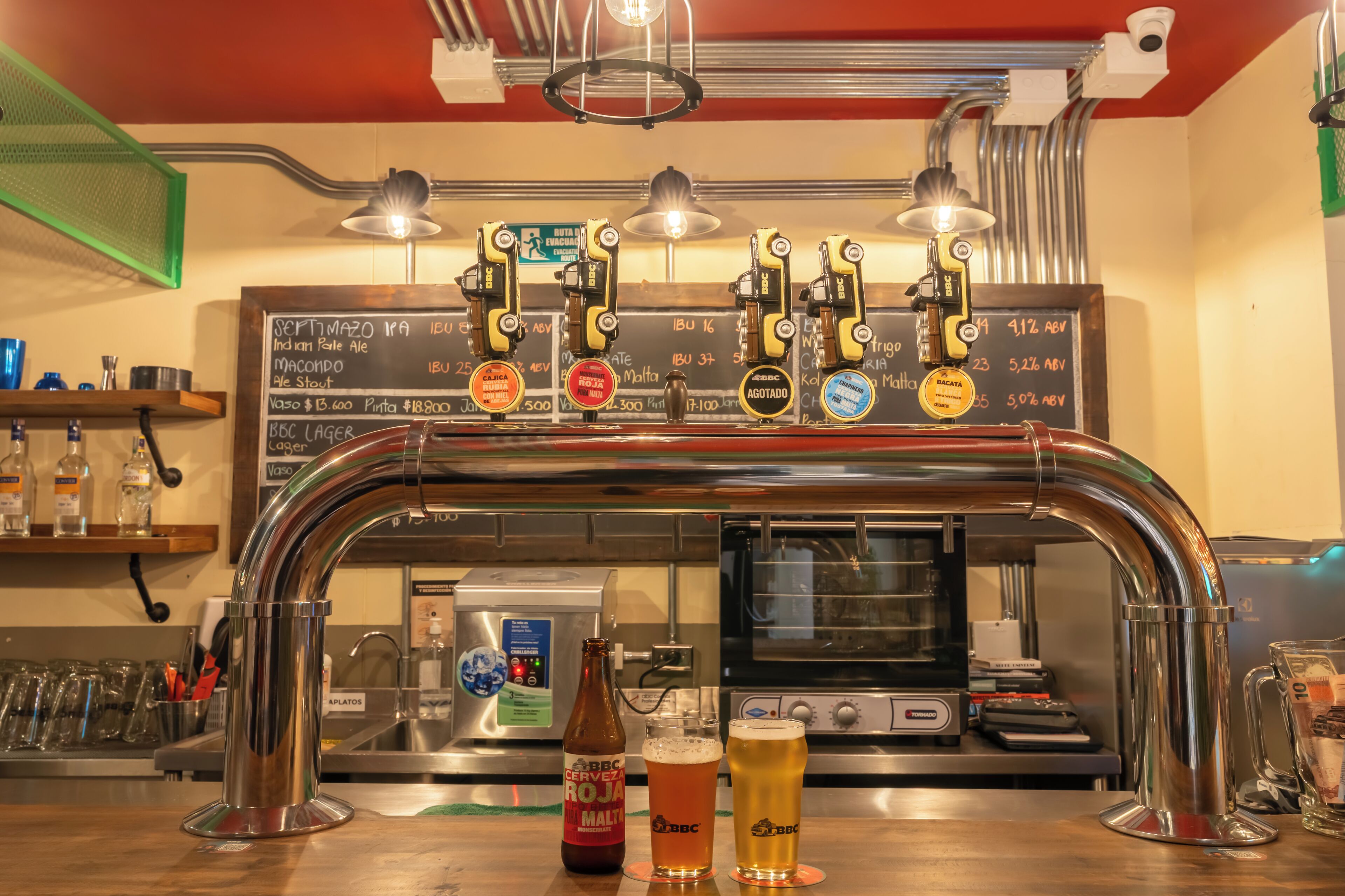 A bar area with a tap system, a beer bottle, and glasses.