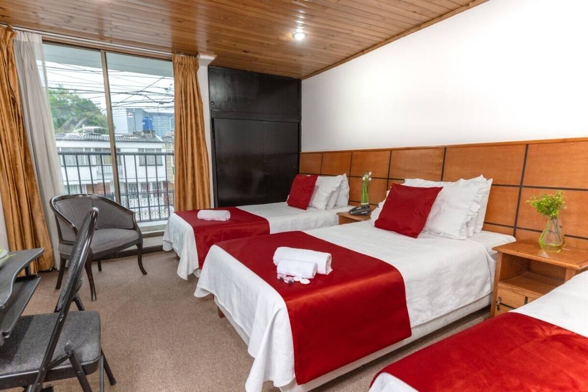 Habitación de hotel con dos camas, un escritorio y una silla.