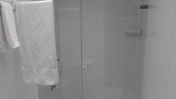 Un baño moderno con ducha de vidrio, inodoro y lavamanos.