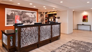 A reception desk with a patterned design, a framed picture on the wall, and a small kiosk with a water bottle. - Hampton Inn El Centro (El Centro)