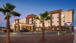 A Hampton Inn hotel with a modern design, featuring a prominent entrance and palm trees in the foreground. - Hampton Inn El Centro (El Centro)