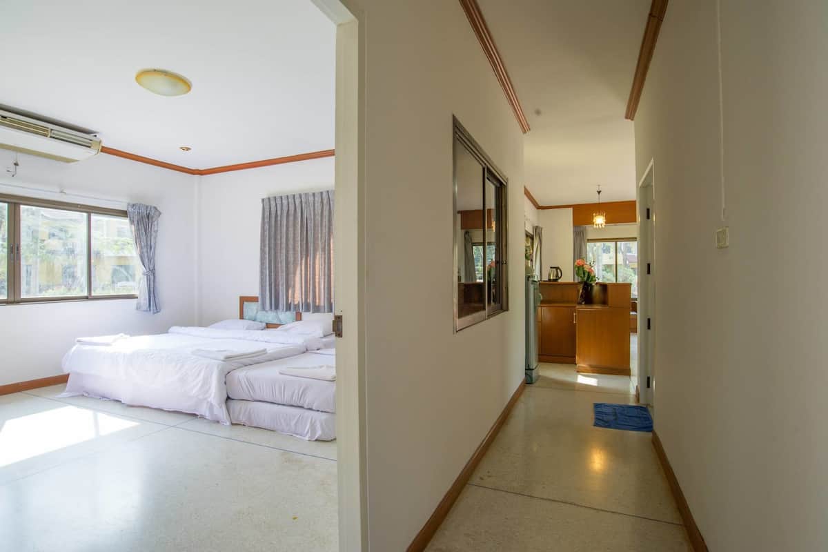 A hotel room with a large bed, a desk, and a view of the outside.