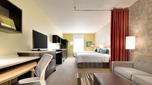 A hotel room with a desk, chair, bed, and a sofa. - Home2 Suites by Hilton Cleveland Independence (Independence)
