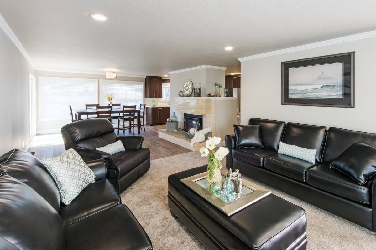 A modern living room with leather sofas, a coffee table, and a fireplace.