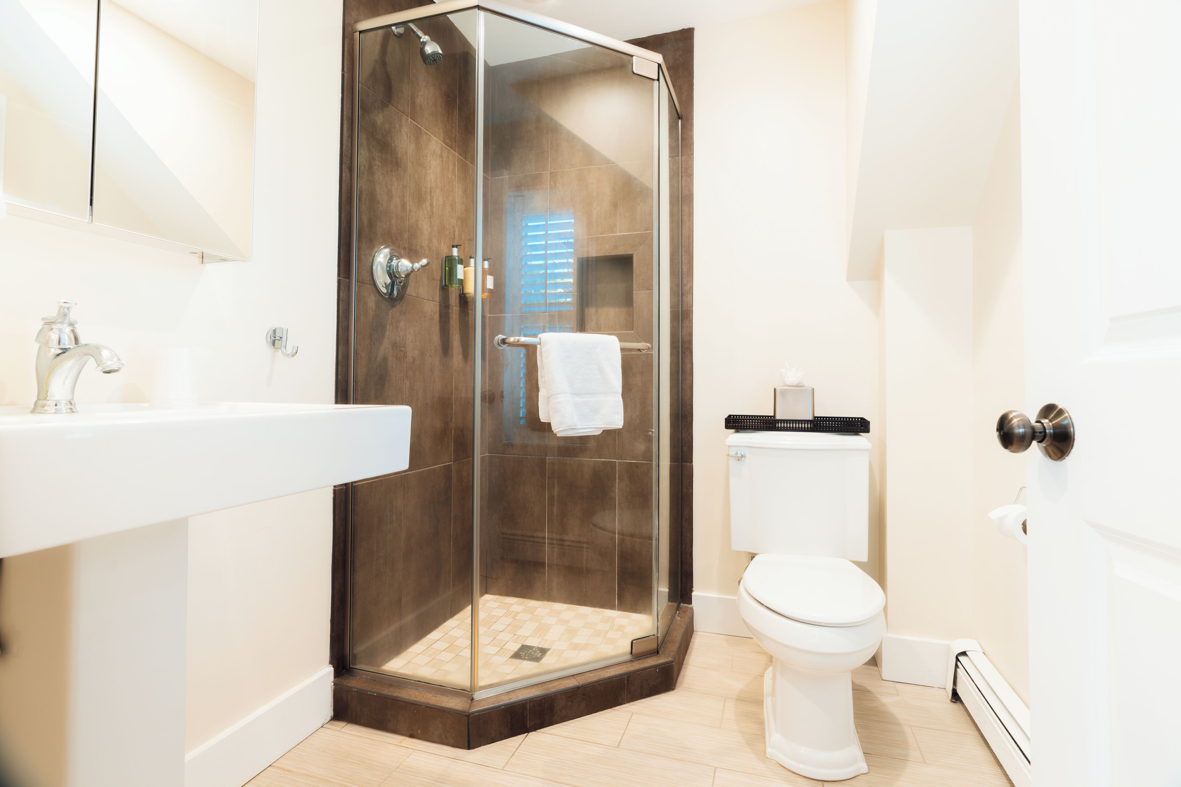 Une salle de bain moderne avec une douche à parois de verre, un lavabo blanc et des toilettes.