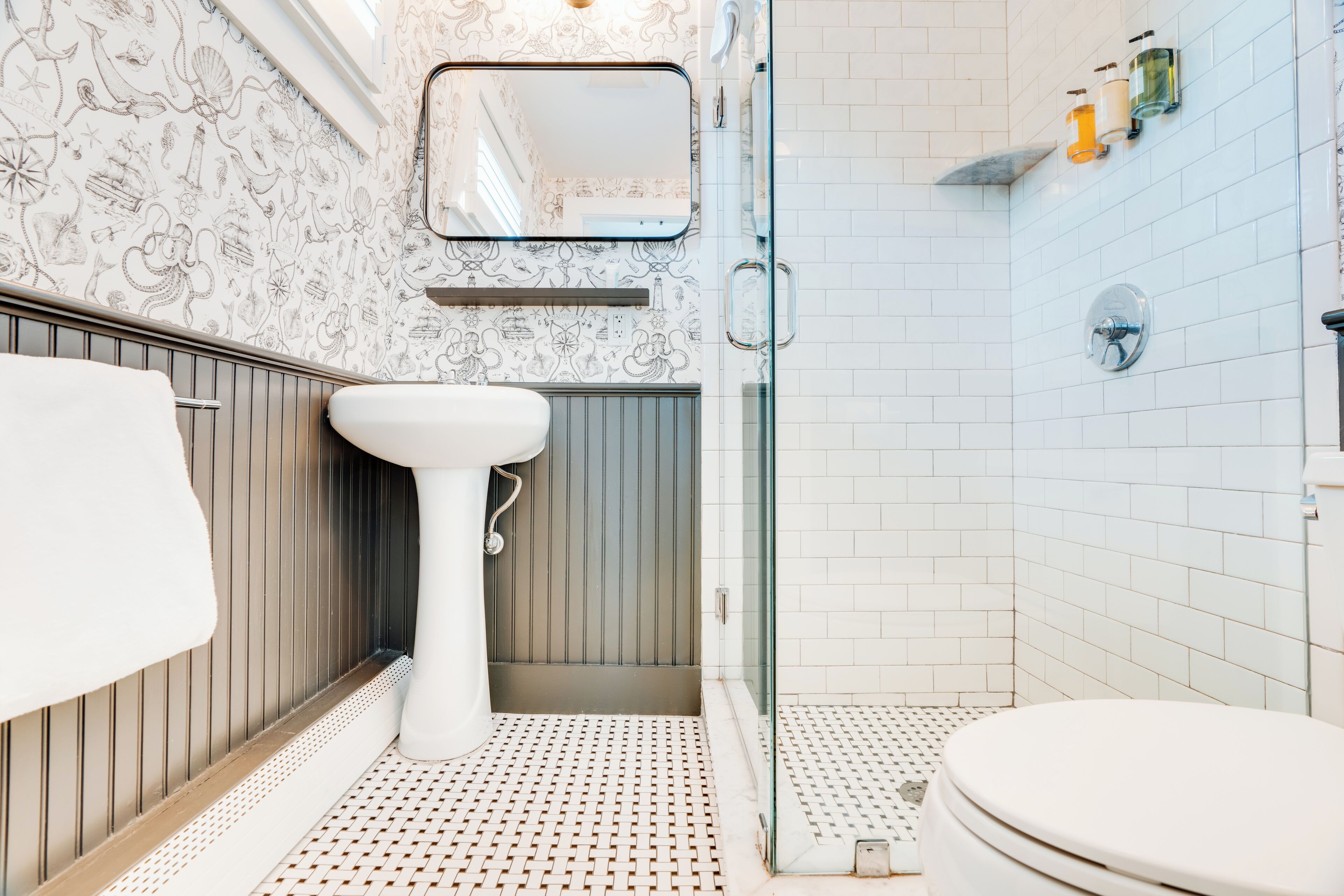 A bathroom with a white sink, a toilet, and a shower area.
