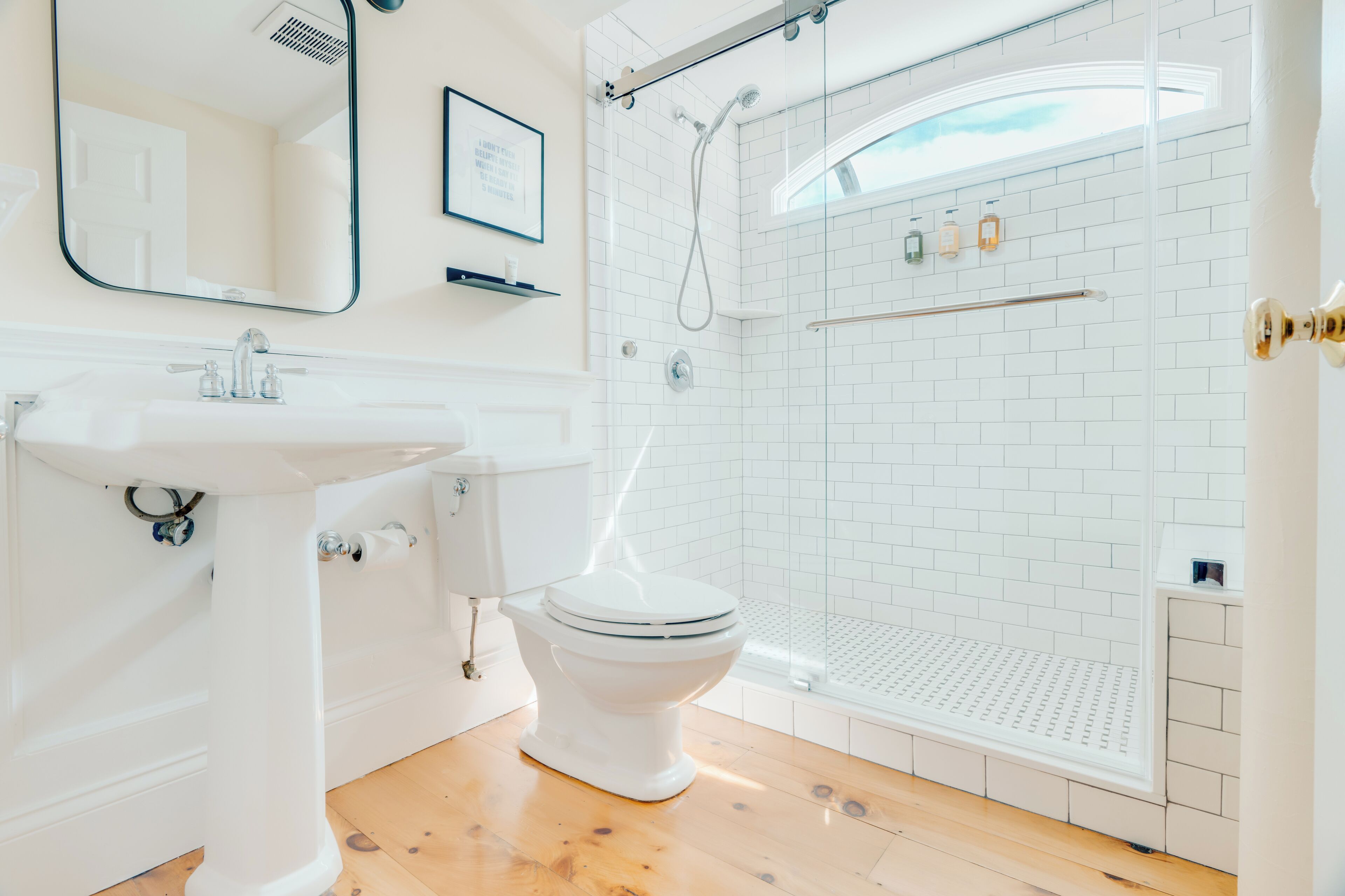 Ein modernes Badezimmer mit einem weißen Waschbecken, einer Toilette und einer Dusche.