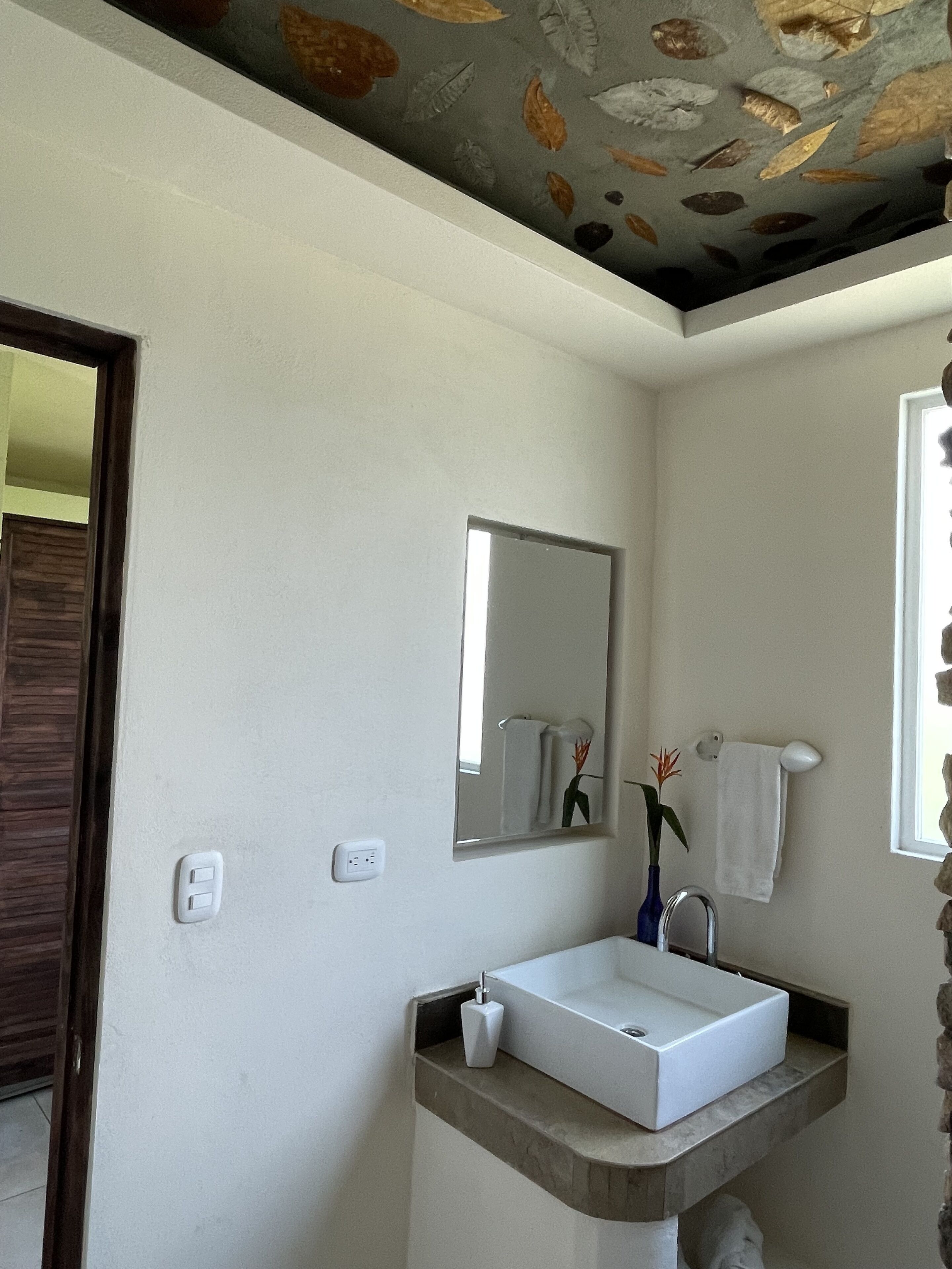 Une salle de bain avec un lavabo blanc, un miroir et un porte-serviettes.