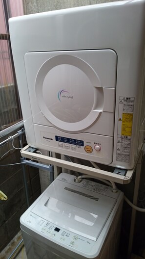 A white Panasonic washer with a control panel and a water inlet.