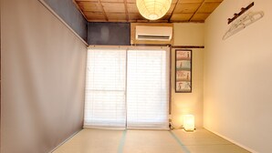 A traditional Japanese room with tatami flooring, a sliding door, and a ceiling fan. - Oyado Tofukuji (Kyoto)