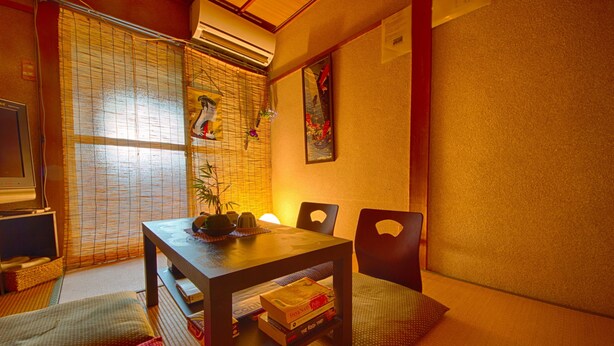 A traditional Japanese room with tatami mats, a low wooden table, and a sliding door with a decorative screen. - Oyado Shogoin (Kyoto)