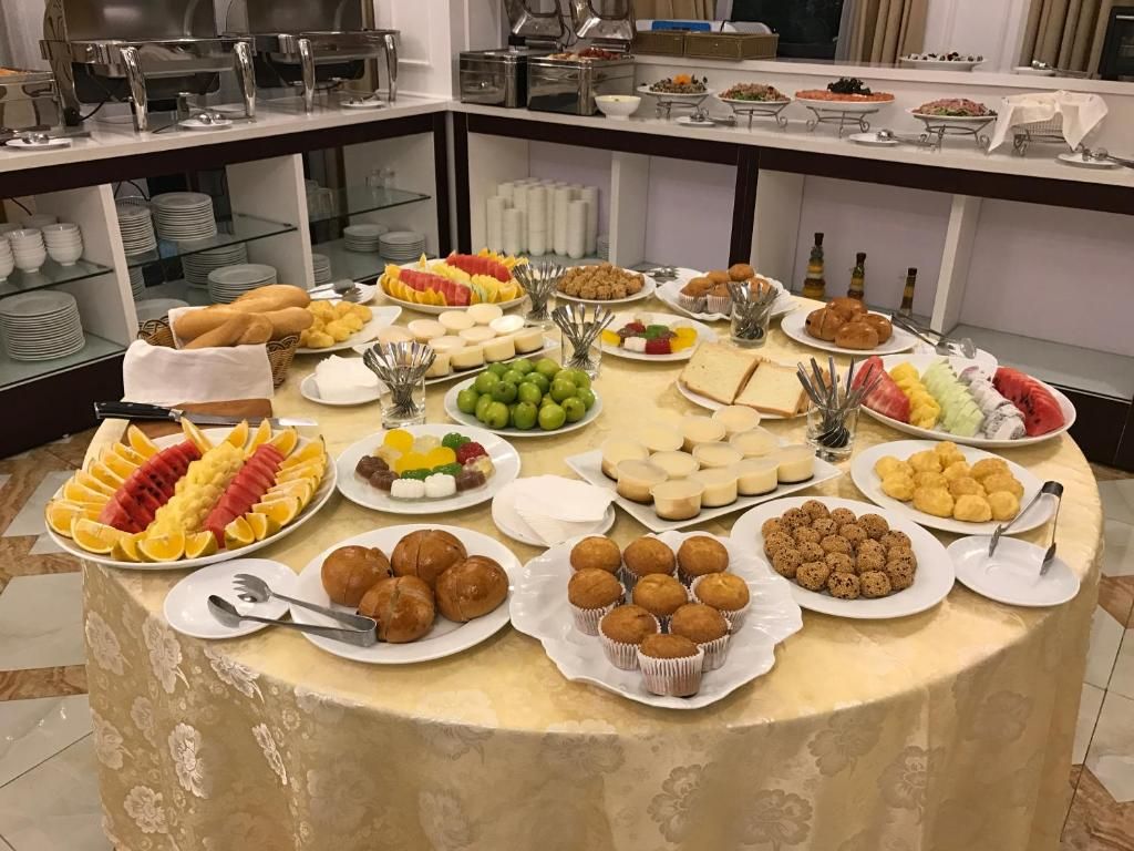 A buffet table with various food items and utensils.