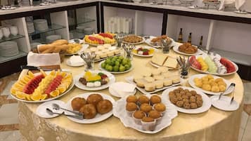 A buffet table with various food items and utensils.