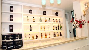 Exposição bem iluminada de bebidas alcoólicas com diversas garrafas e caixas, incluindo Ricossa e Piemonte Barbera.