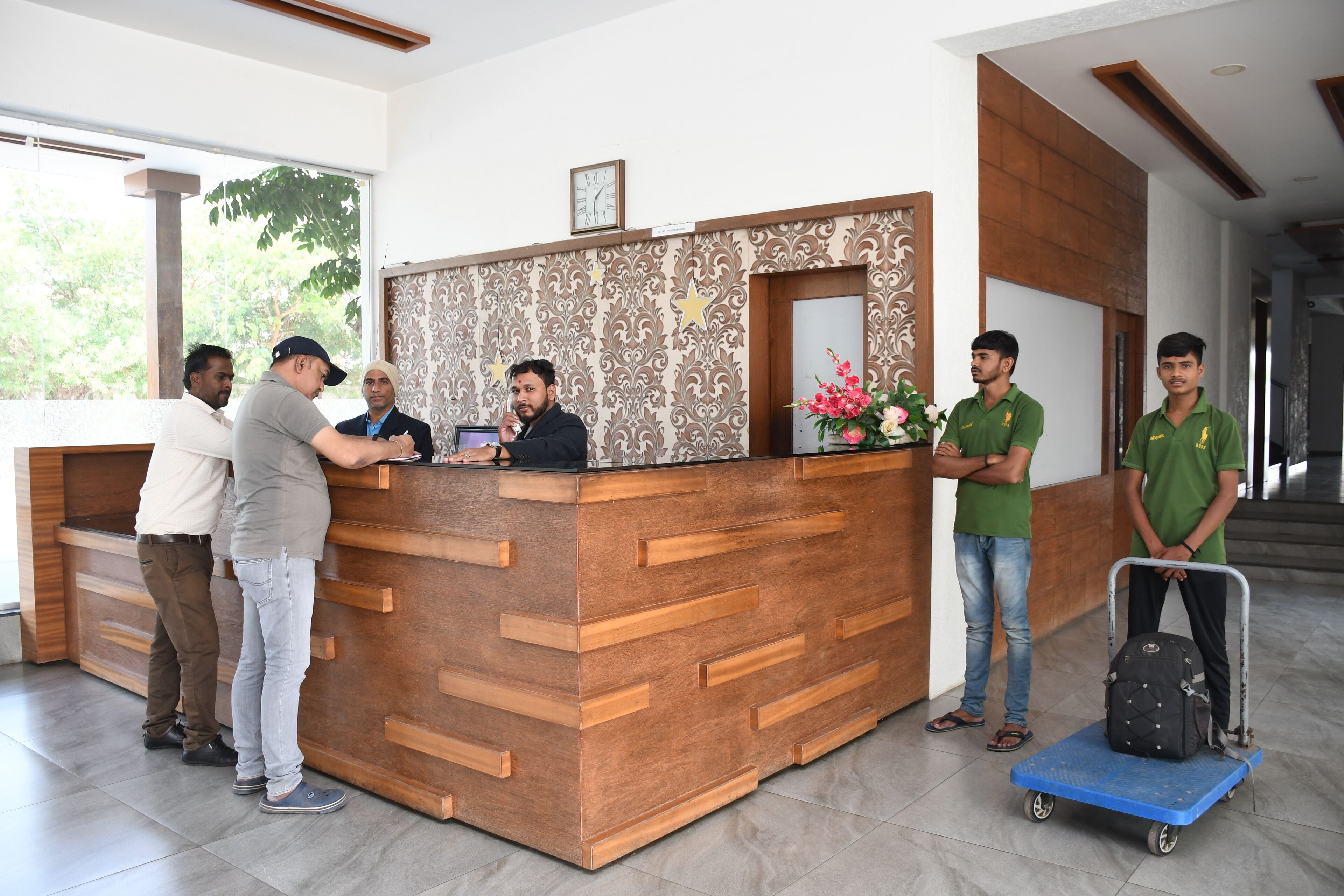 A reception desk with a wooden finish and a decorative wall.