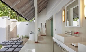 A modern bathroom with a large mirror, a bathtub, and a shower area. - NH Maldives Kuda Rah Resort (Kuda Rah)