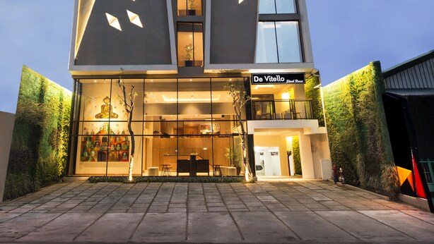 Un edificio moderno con un diseño angular distintivo, con ventanas amplias y una entrada bien iluminada.