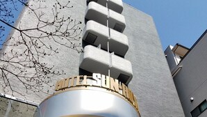 Un edificio moderno con un letrero llamativo que dice "HOTEL SUNRISE".