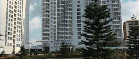 Un moderno edificio de gran altura con una piscina en primer plano.