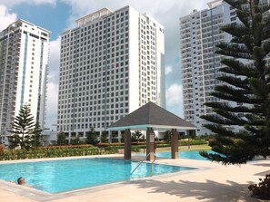 A modern residential building complex with a swimming pool and a gazebo. - The Concierge at Wind Residences Tagaytay (Tagaytay)