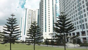 A modern high-rise building with a central courtyard and surrounding greenery. - The Concierge at Wind Residences Tagaytay (Tagaytay)