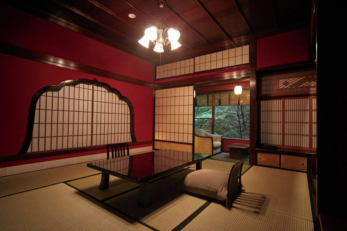 A traditional Japanese room with tatami flooring, a low table, and shoji screens.