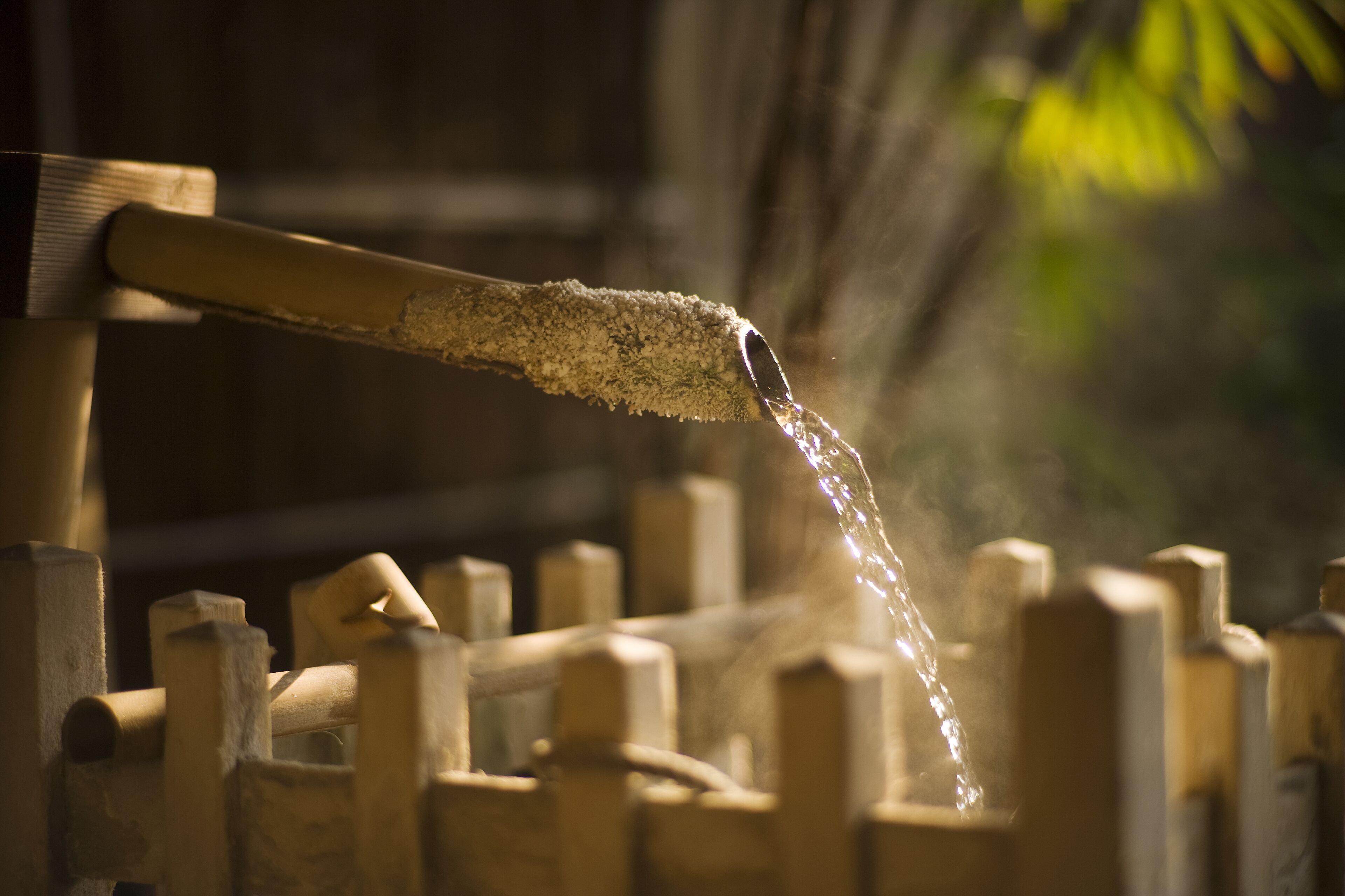 A water spout with water flowing over a wooden structure.