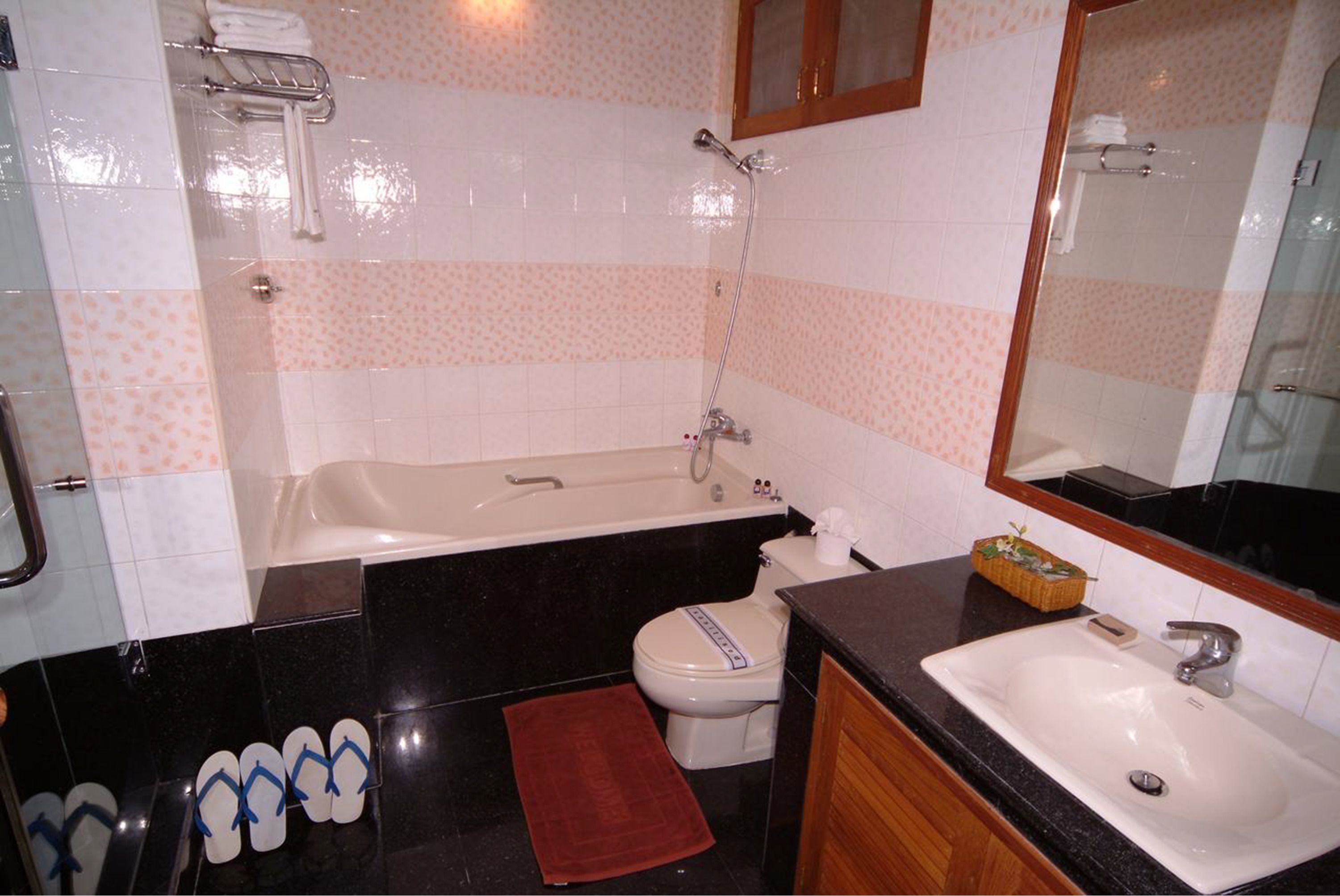 Een badkamer met een bad, toilet, wastafel en een spiegel.