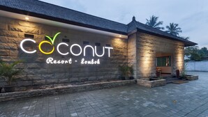 A stone building with a sign that reads "Coconut Resort - Lombok."
